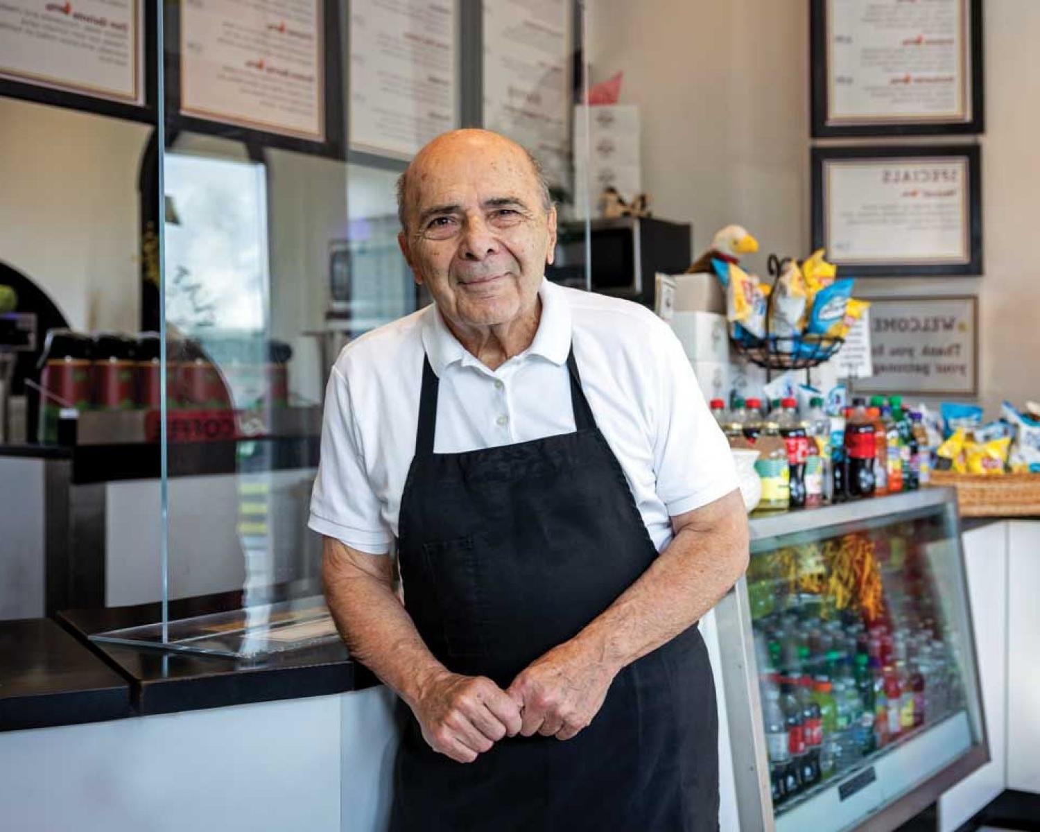 Photo of John Acampora at the counter of his Flat Breads shop