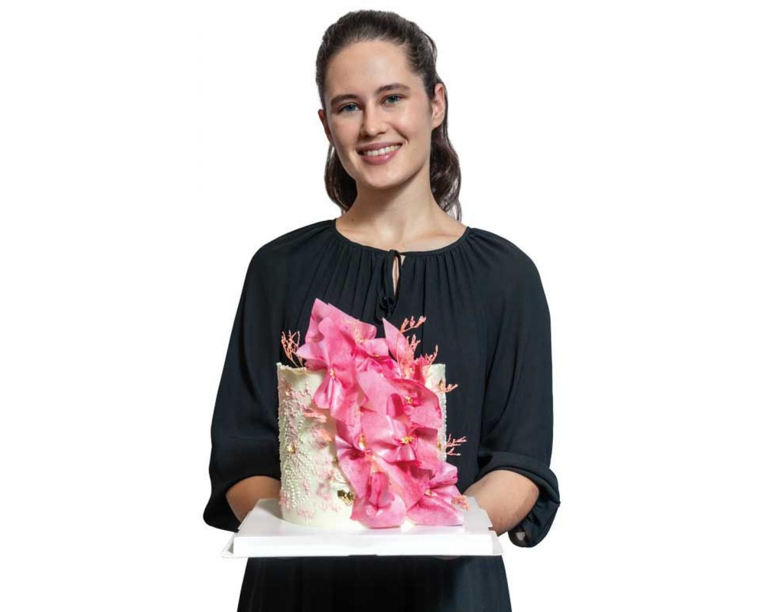 Photo of Ilona Znakharchuck ’21 holding one of her beautifully decorated cakes